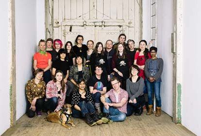a group photo of shoemakers in a warehouse space