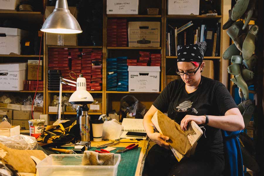 a shoemaker fitting leather around a wooden template