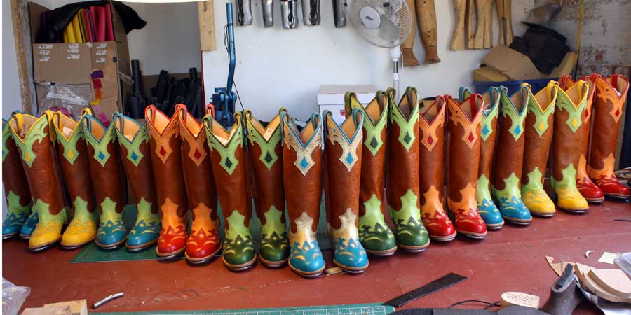 a row of custom pairs of cowboy boots