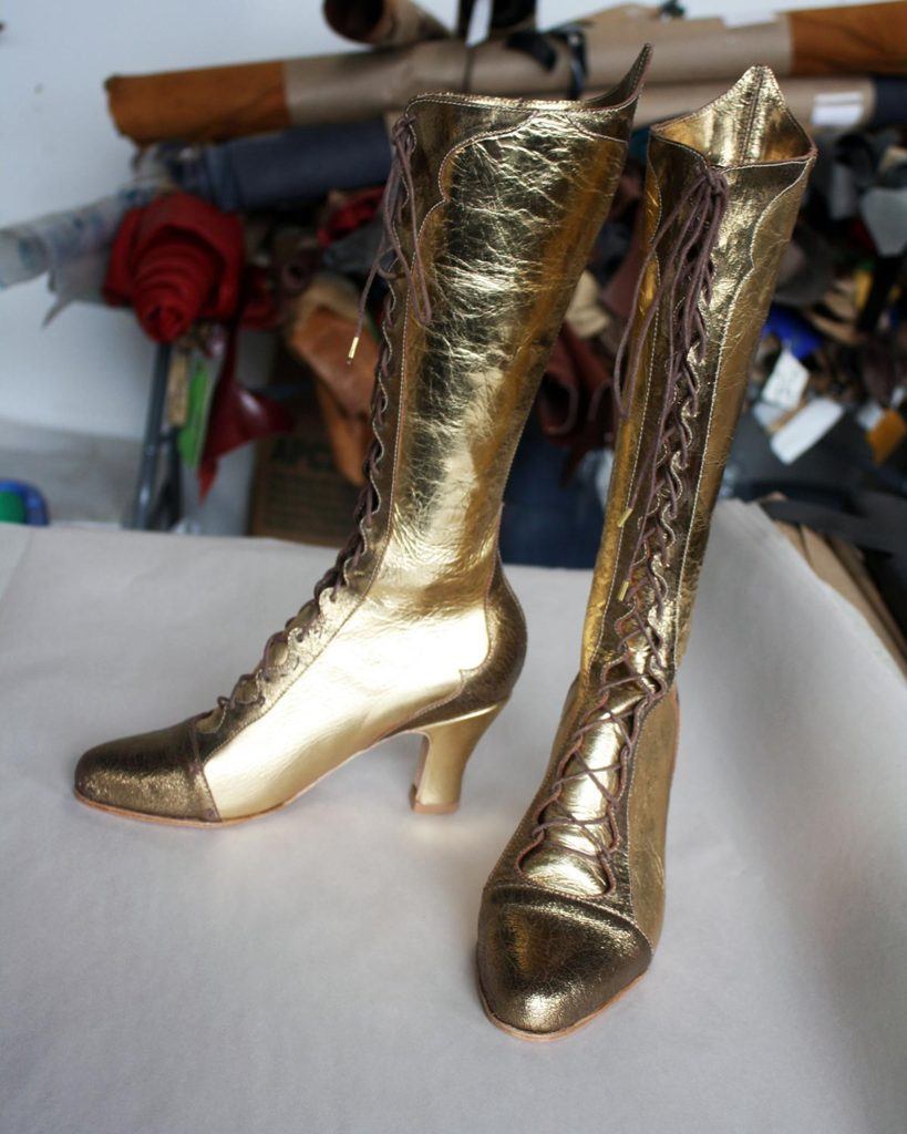 a pair of custom gold high heeled boots