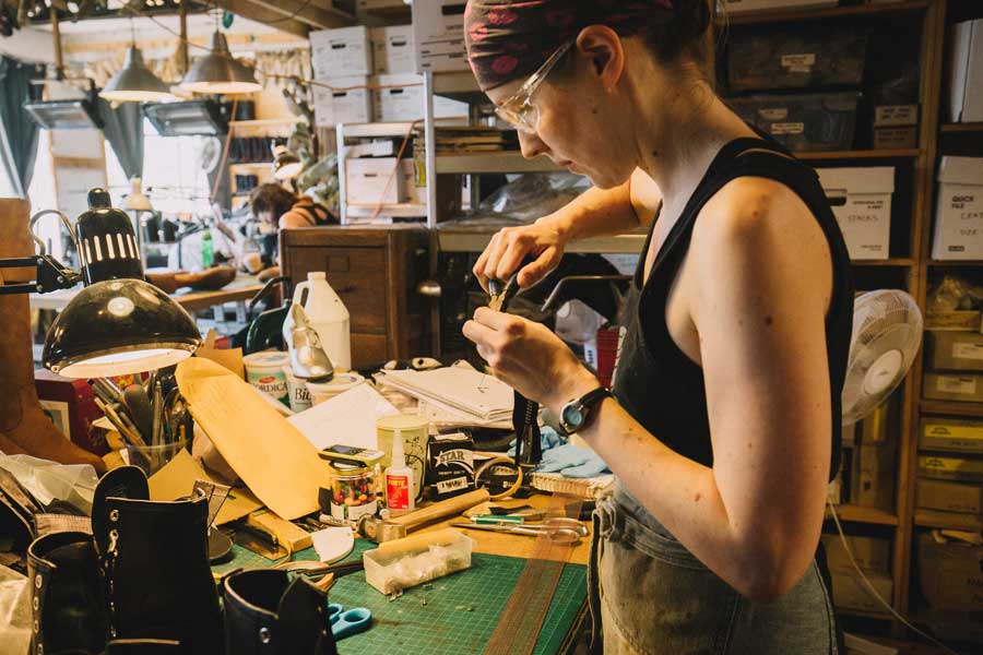 a shoemaker working with pliers in a shoe workshop