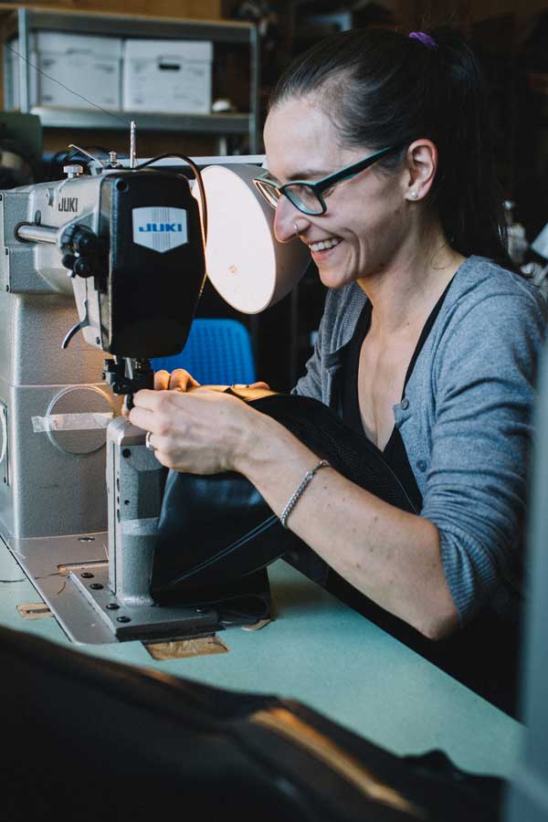 a lady stitching shoe in warehouse