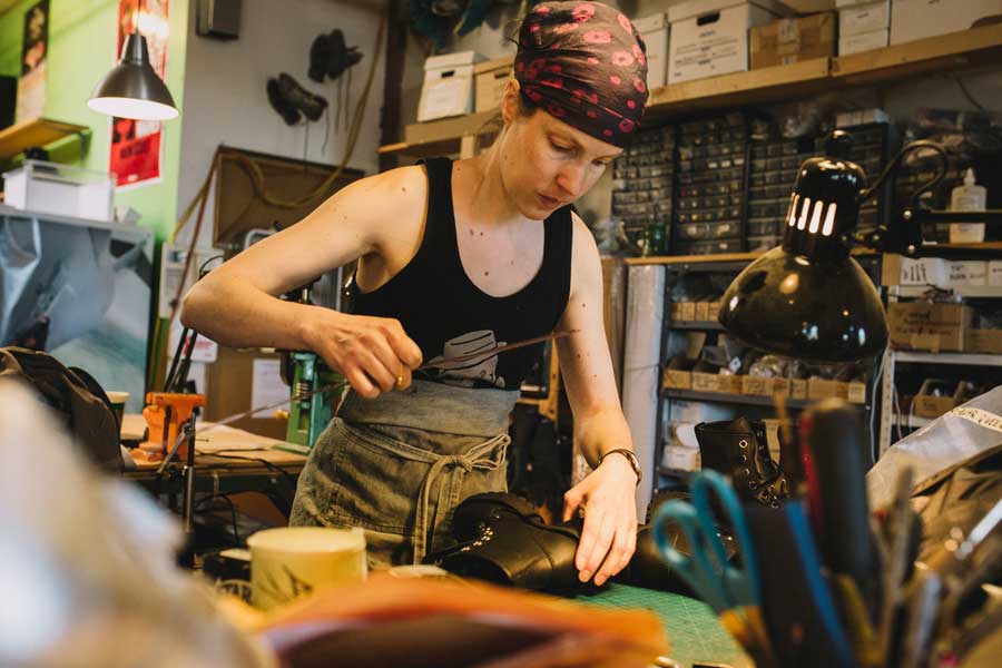 A lady cutting shoe design in warehouse