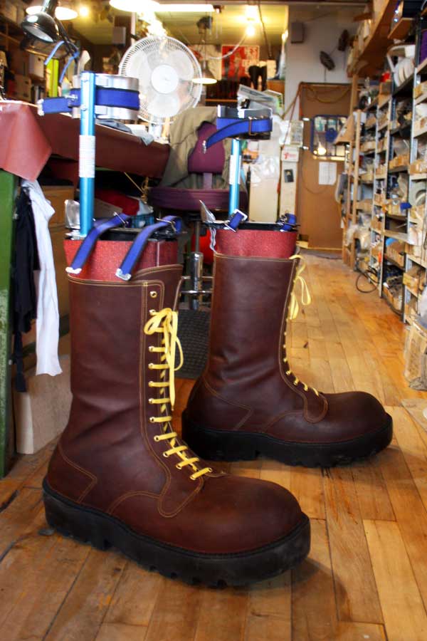 a pair of brown boots with yellow lace