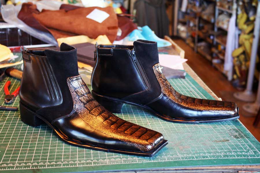a pair of black & brown alligator like shoes with zip