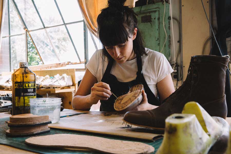 a shoemaker working on a pair of custom shoes