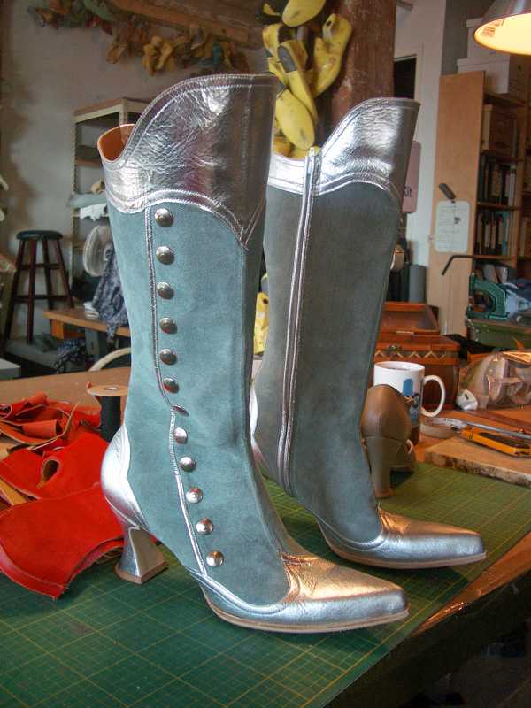 pair of silver & green long boots with heels