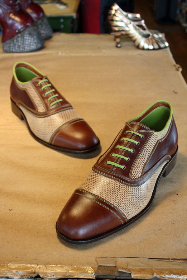 white and brown shoes with green laces