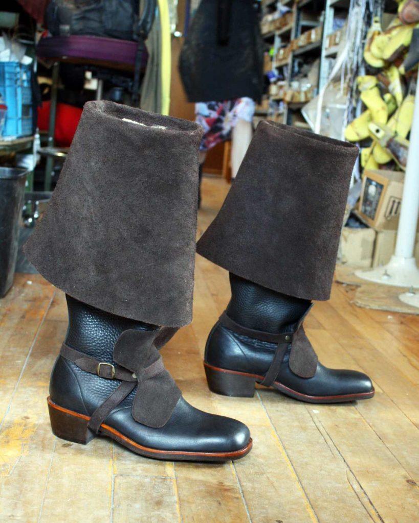 pair of black period boots with straps