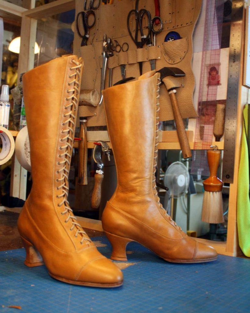 pair of long brown boots with heels and lace up