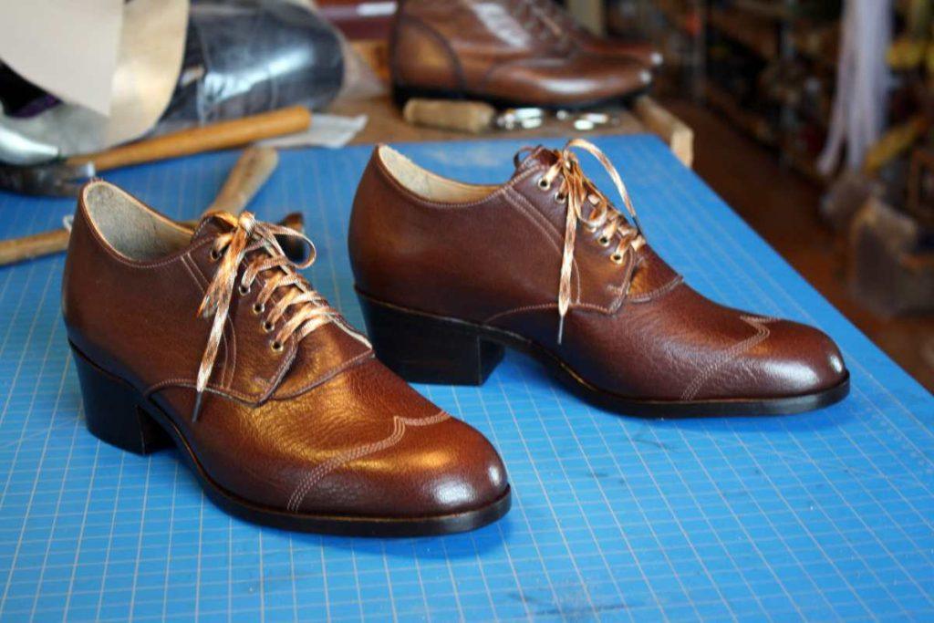 pair of brown leather shoes with lace and heels