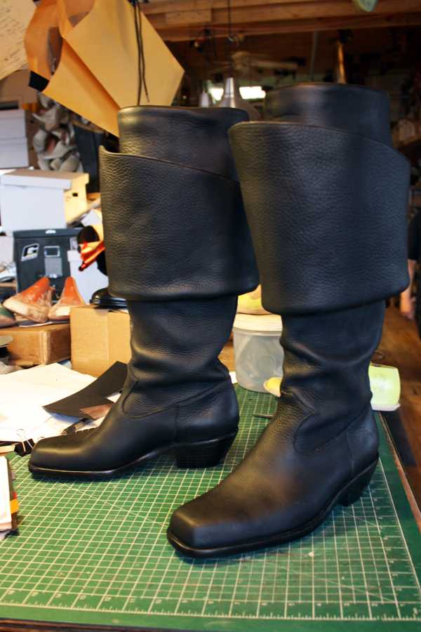 pair of black long period boots with heels