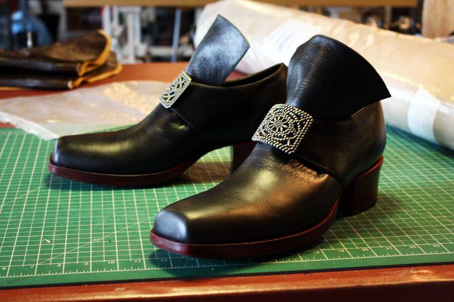 black shoes with raised heel and ornate buckle