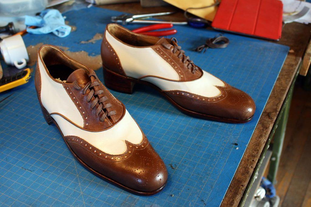 a pair or brown & white leather shoes with heels