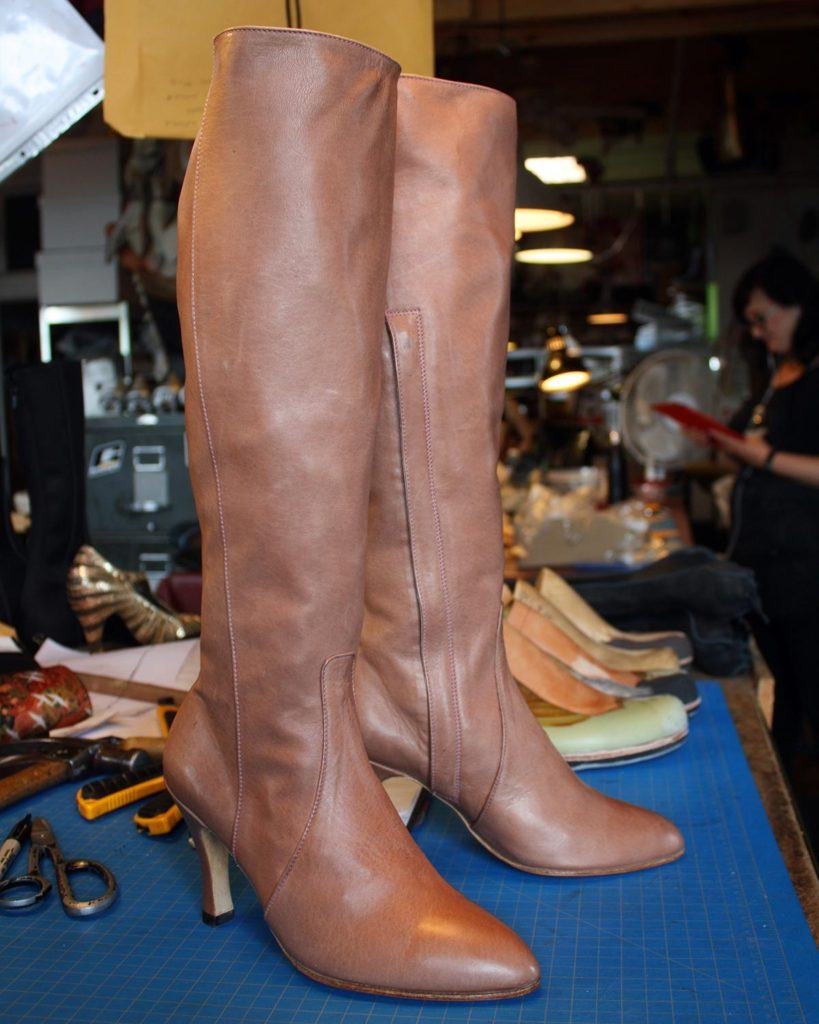 a pair of custom brown long boots with high heels