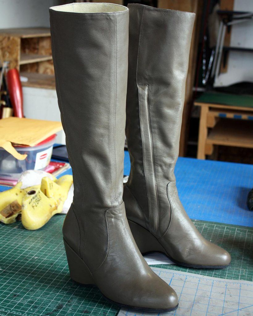 a pair of custom green long leather boots