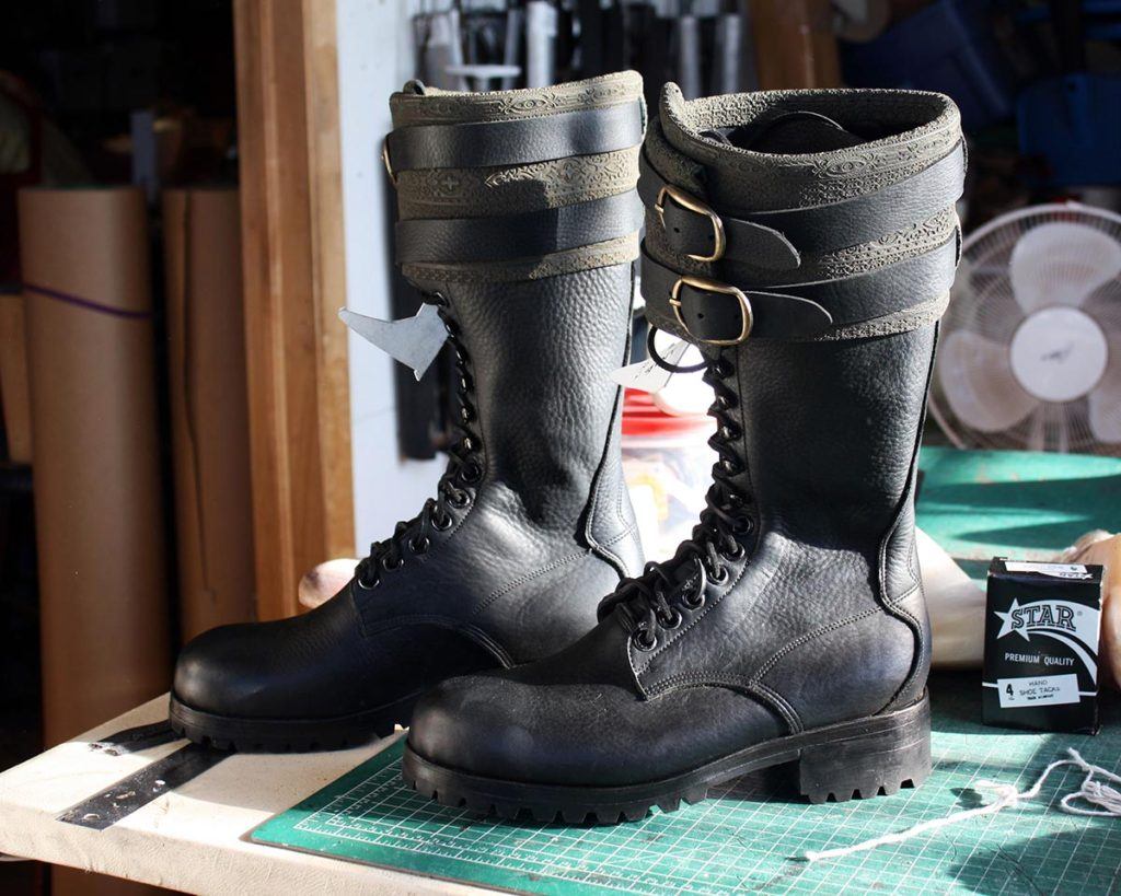 a pair of black leather boots with buckle