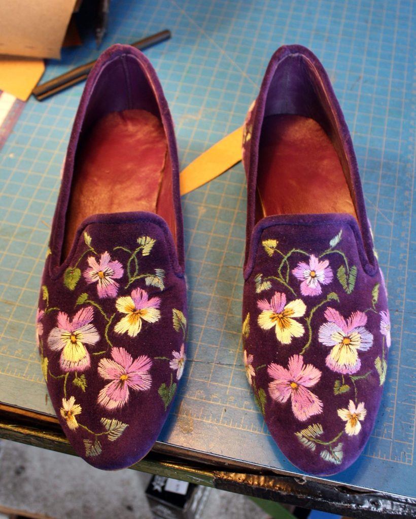 a pair of custom blue shoes with floral embroidery