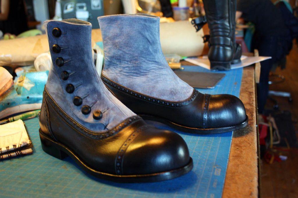 a pair of custom blue & black boots with buttons