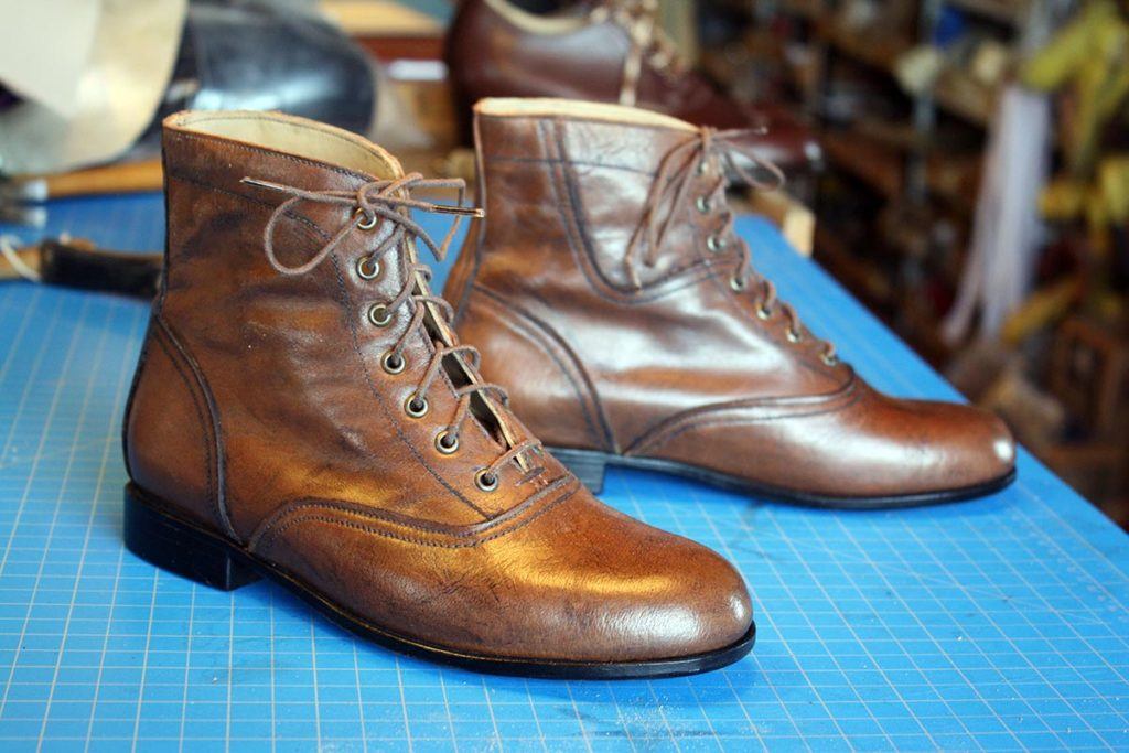 a pair of brown ankle length leather shoes with lace
