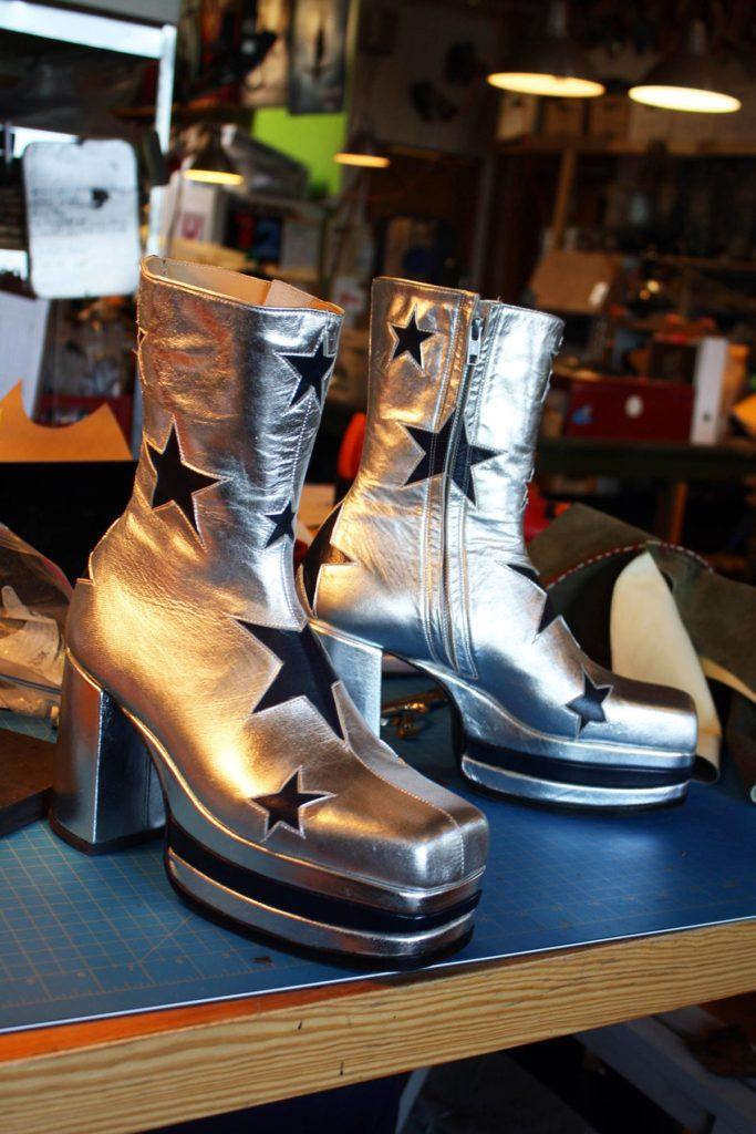 a pair of stylish silver boots with black star with heels
