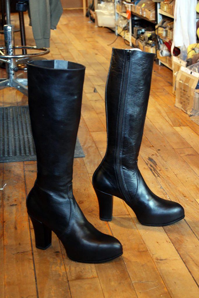 pair of black leather high heel boots with zip