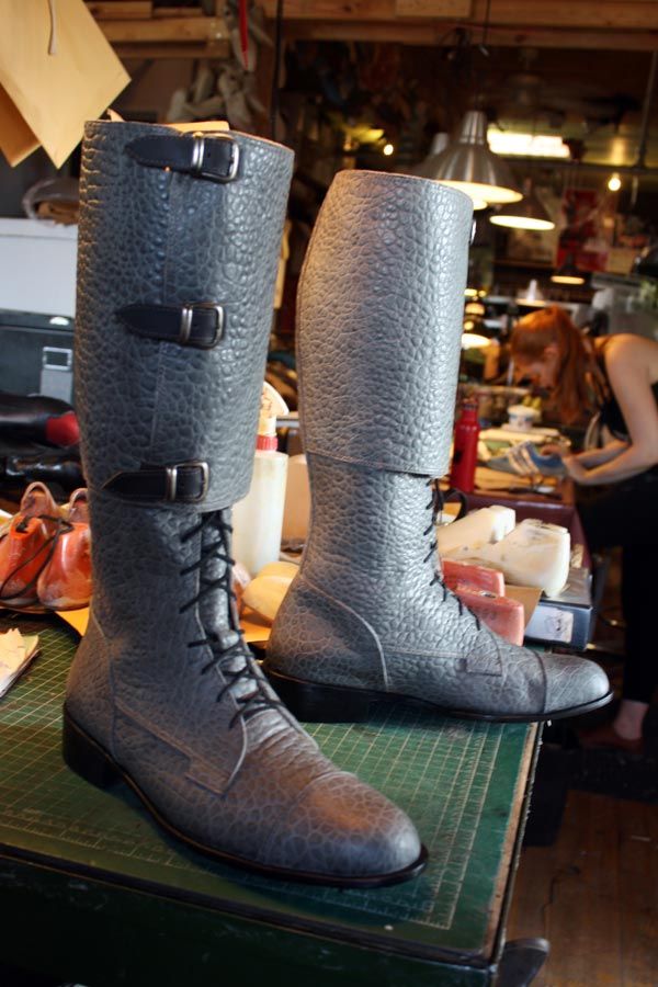 pair of grey long boots with buckle and lace